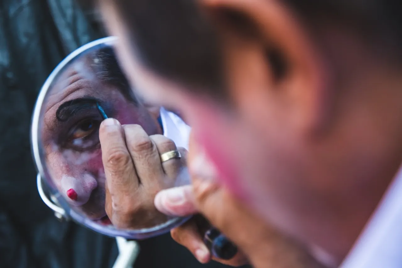 No detalhe, outro Celso Alberto Stevanovich, este pai do intérprete do palhaço Moroco, se prepara para entrar em cena numa das poucas apresentações feitas pelo Cirque Amar durante a pandemia. O artista dá vida ao palhaço Matraca