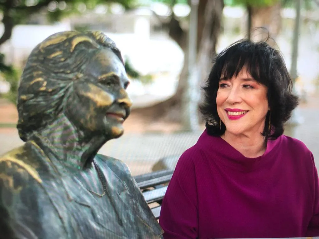 Angela Gutiérrez contempla estátua de Rachel de Queiroz na Praça dos Leões, no Centro de Fortaleza