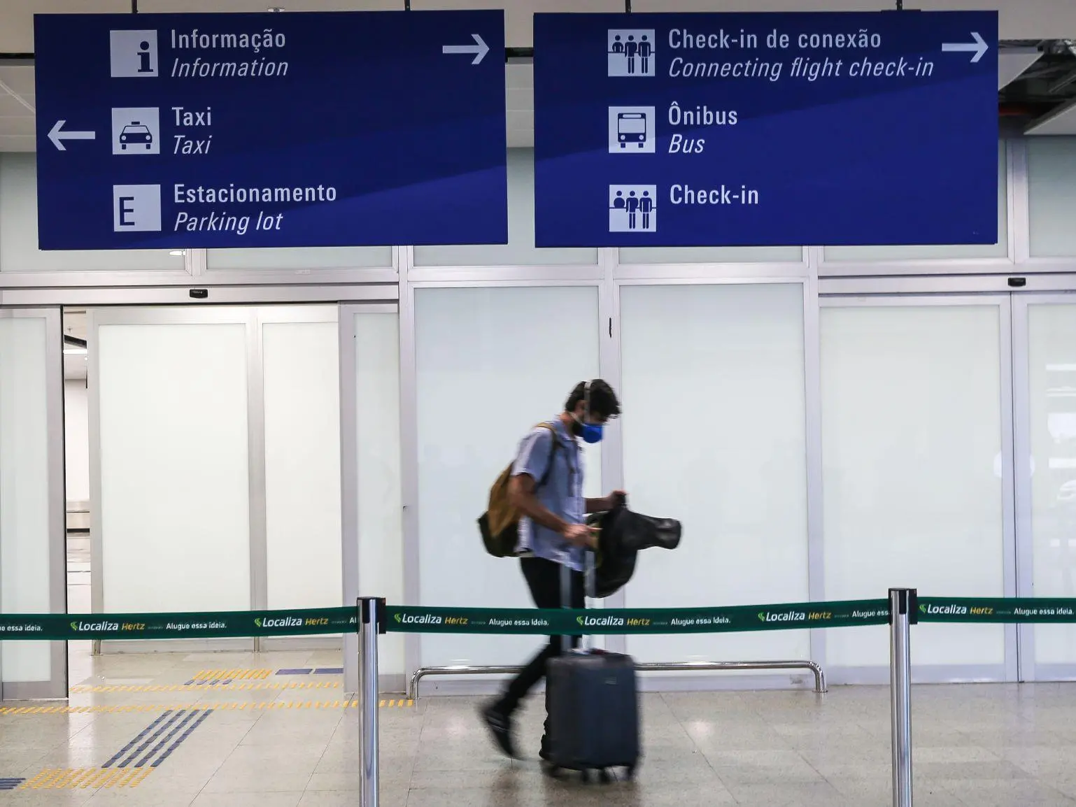 Passageiro transita em aeroporto com máscara