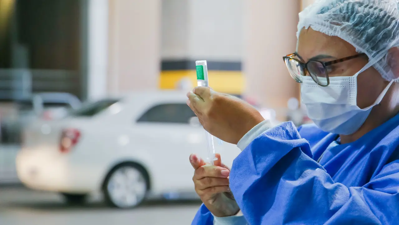 Profissional da saúde preparando dose vacina contra a Covid-19
