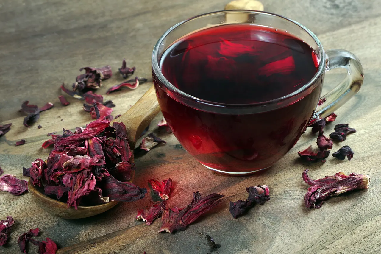 Folhas secas de hibisco e xícara com chá.