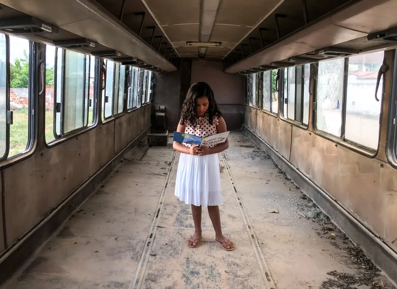 Ana Lívia, 7 anos, lê dentro do ônibus-sucata na comunidade de Espinho - Limoeiro do Norte