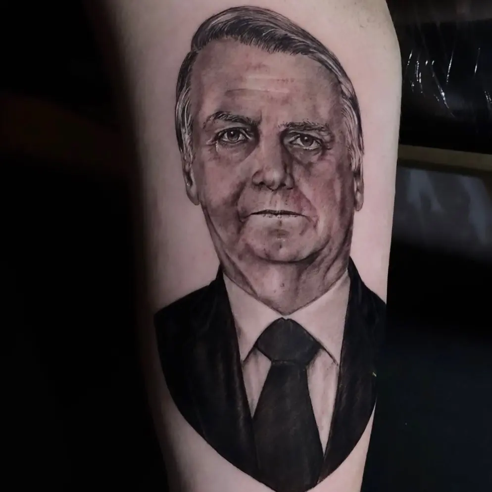 Imagem da notícia: Renan Bolsonaro, filho '04' do presidente, tatua rosto do pai no braço