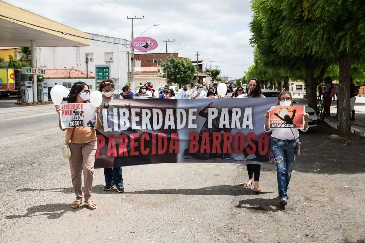 Mulheres caminham com cartazes