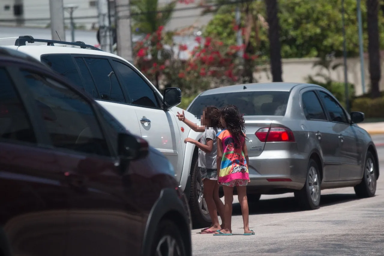 Pequenos se arriscam entre veículos