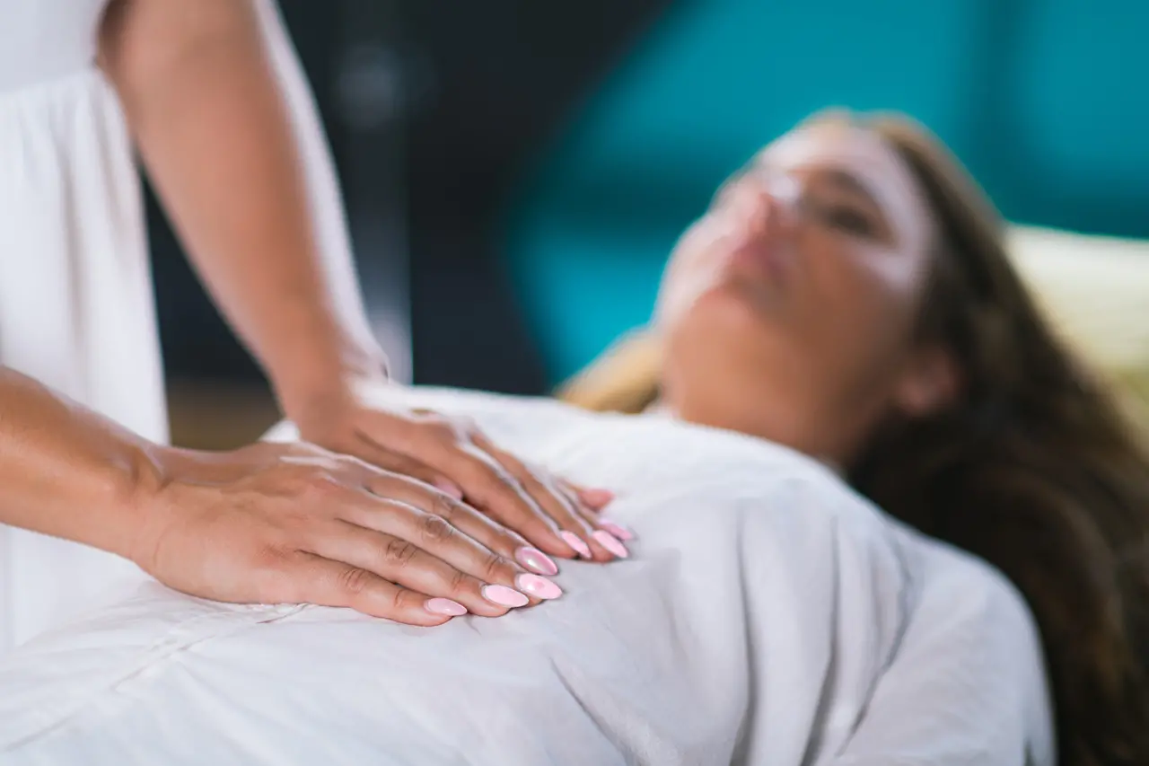 Mãos femininas tocando o abdômen de uma paciente
