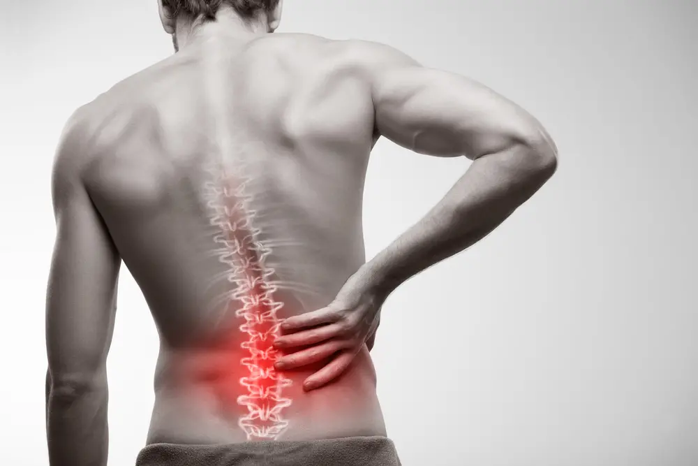 A imagem meramente ilustrativa mostra um homem com a coluna inflamada.