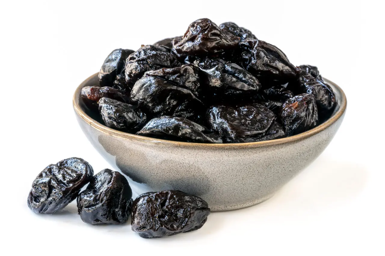 Ameixas secas dentro de um bowl e outras ao redor