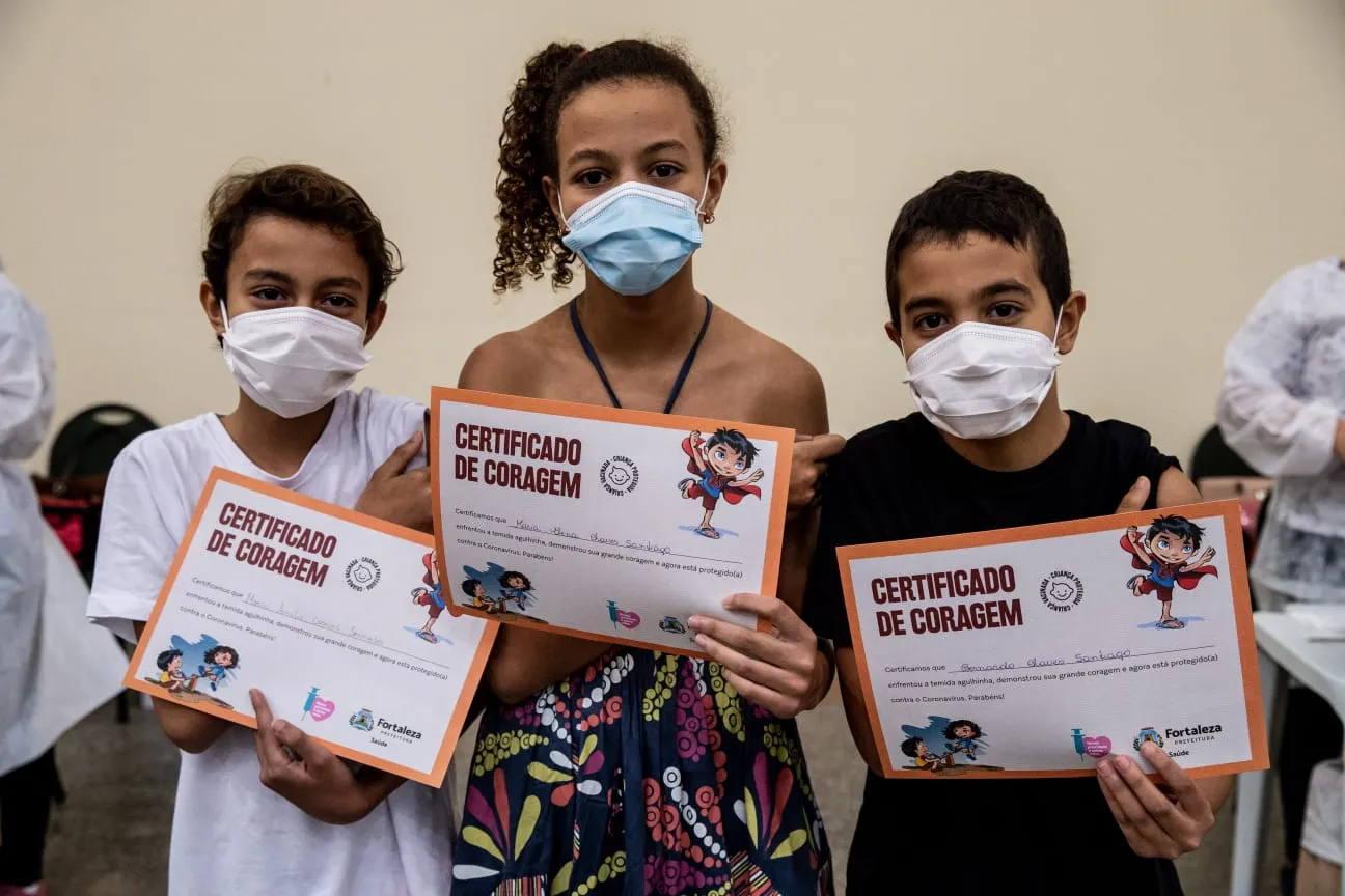 Os três exibem o certificado de coragem depois de enfrentar o medo da agulha da vacinação