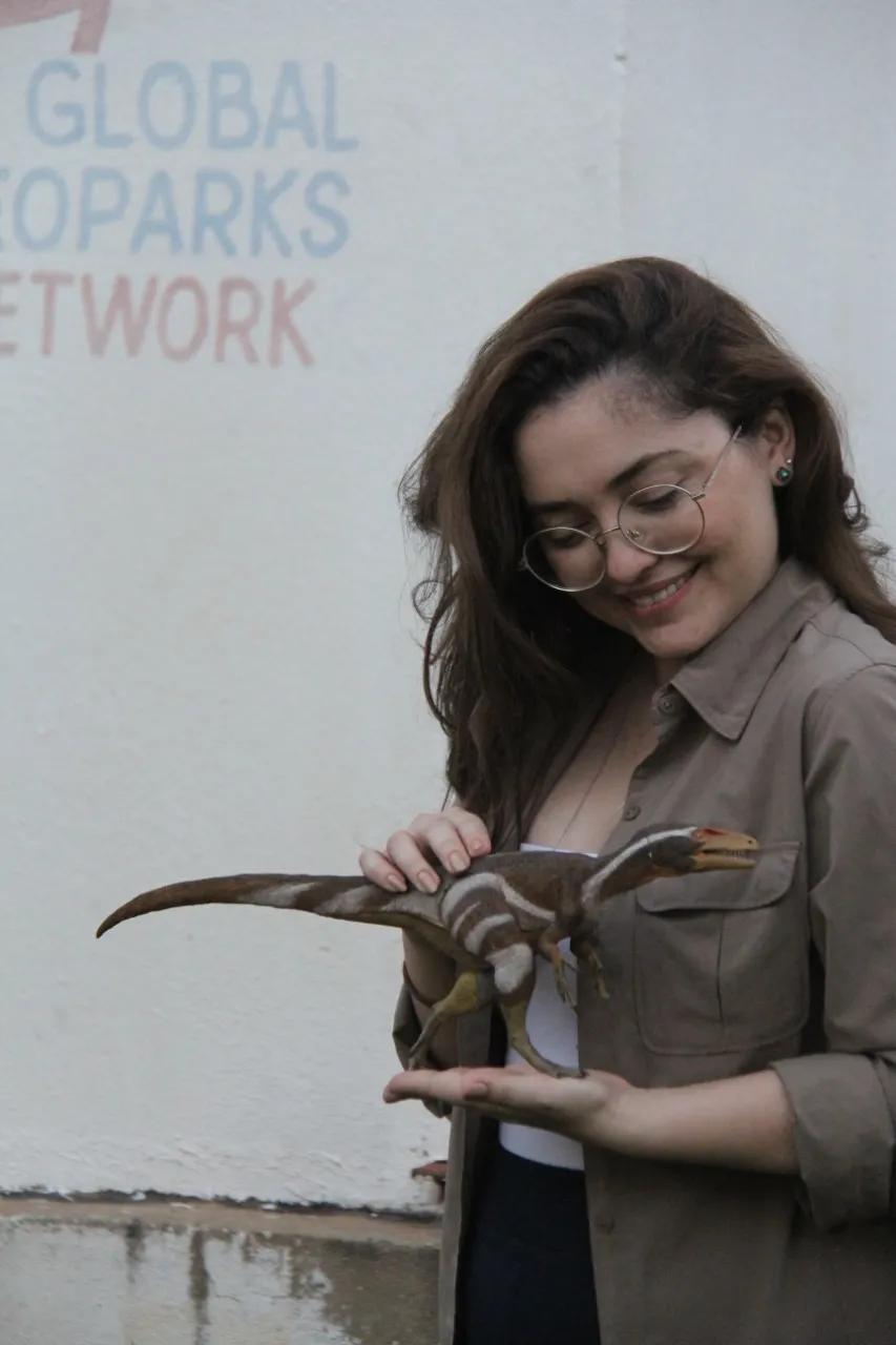 Flaviana posa com réplica do Dinossauro Aratasaurus