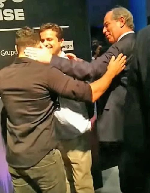 Momento em que Ciro Gomes encosta a mão na nuca de Arthur do Val em evento.