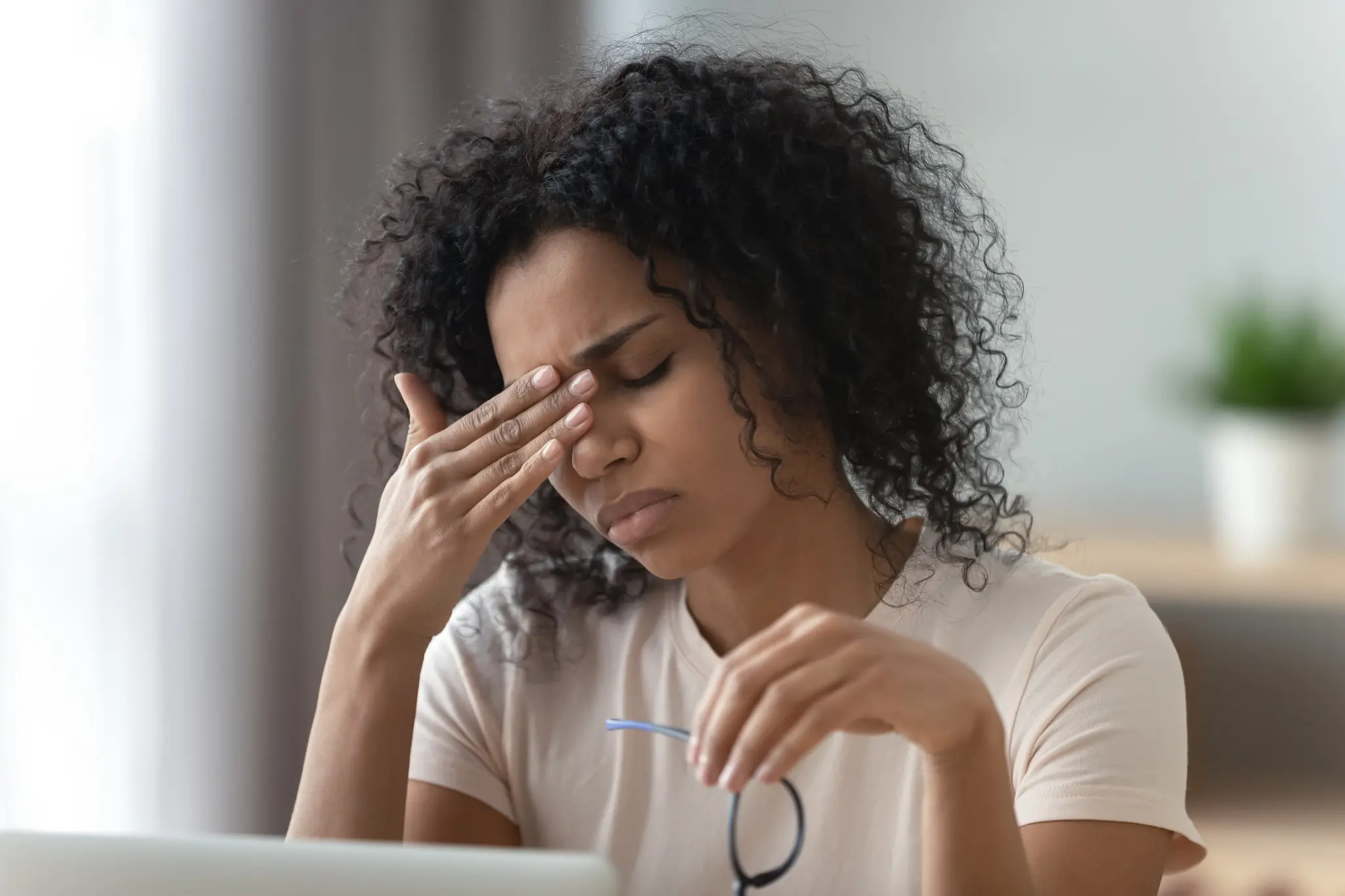 Mulher negra jovem com dor de cabeça