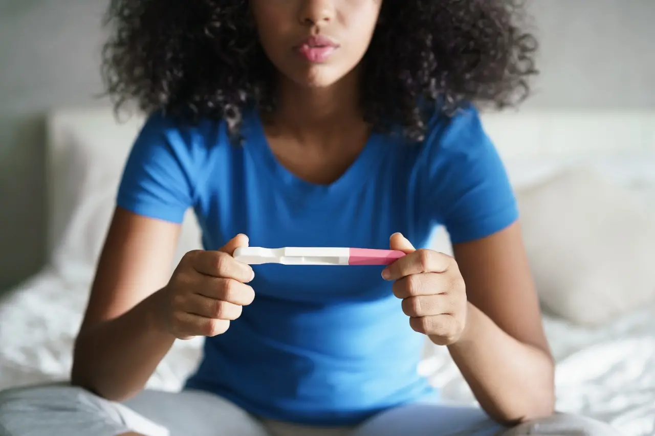 Mulher segurando um teste de gravidez