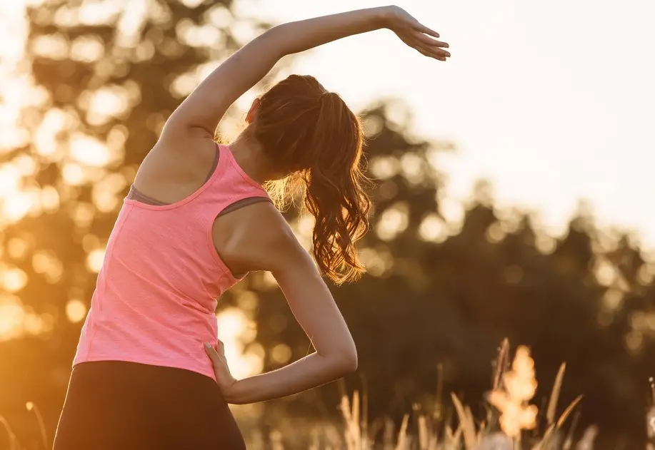 Mulher faz exercícios físicos ao ar livre.