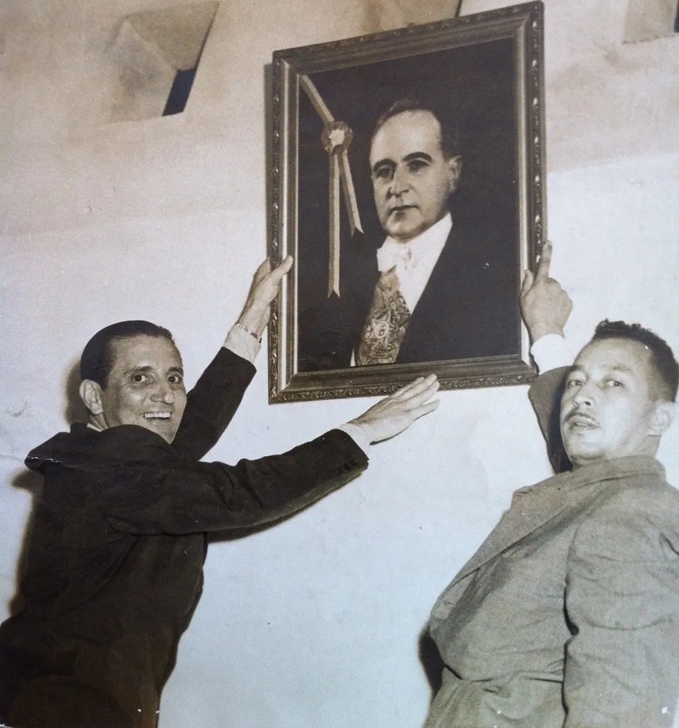 Francisco Alves e Haroldo Lobo colocando o retrato de Getúlio Vargas novamente na parede