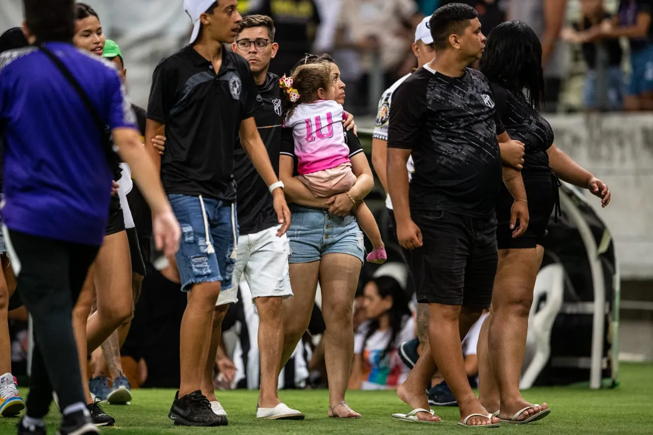 Famílias com crianças ficaram no gramado para fugir de confusão na arquibancada.