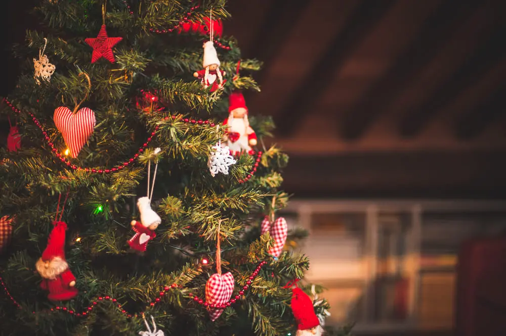 Árvore de natal verde escura com enfeites de natal na cor vermelha
