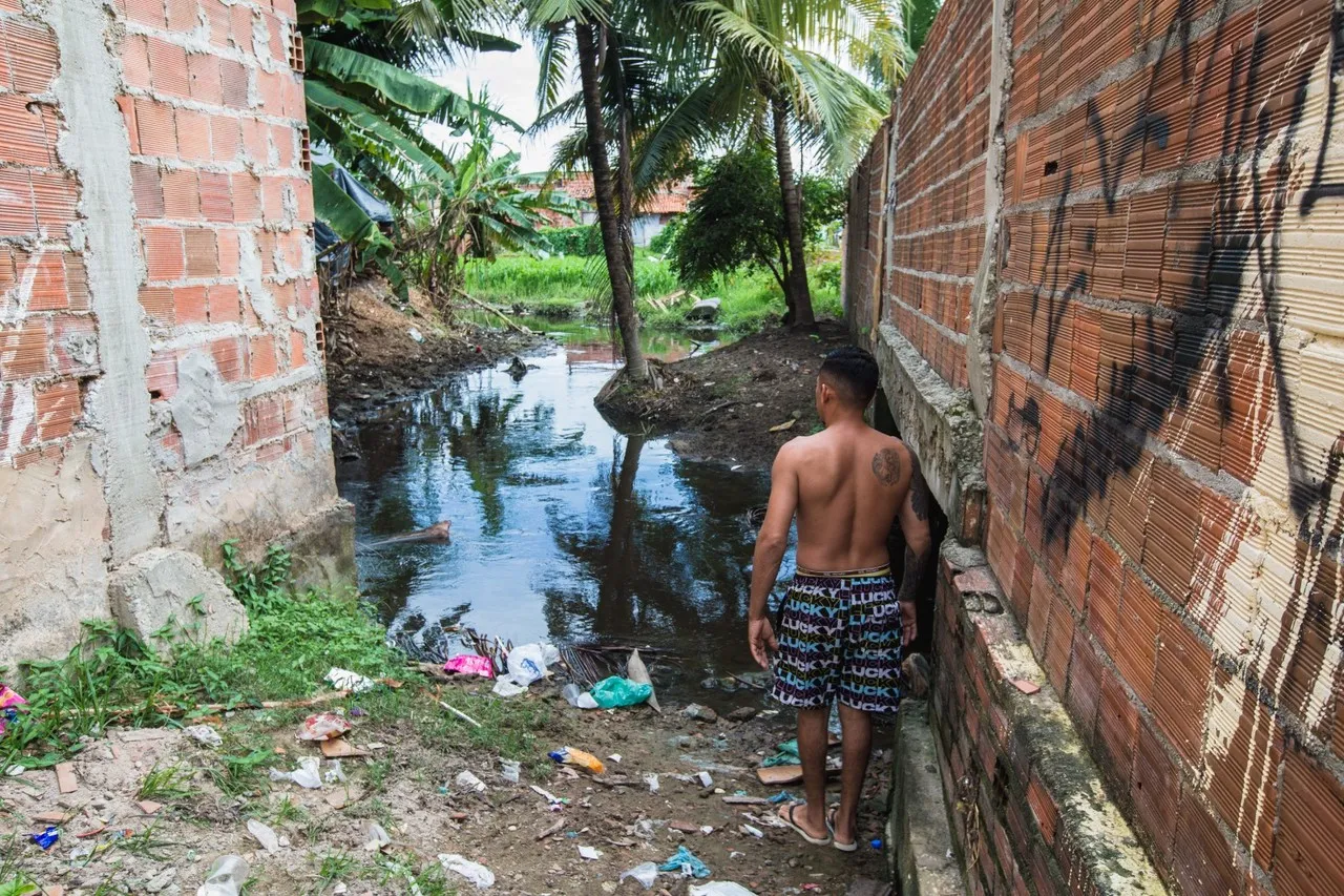 Morador mostra a poluição e a falta de estrutura no canal