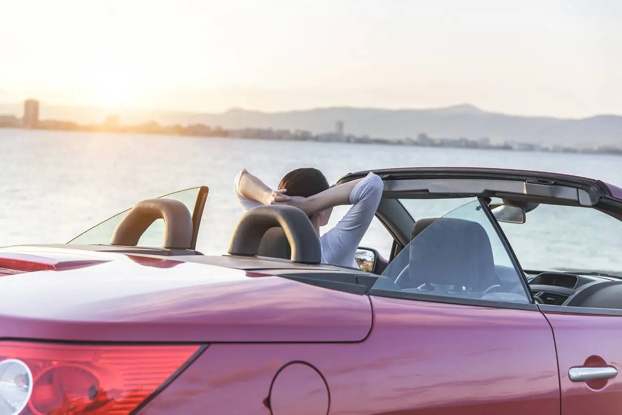 Mulher olhando a paisagem em carro de luxo