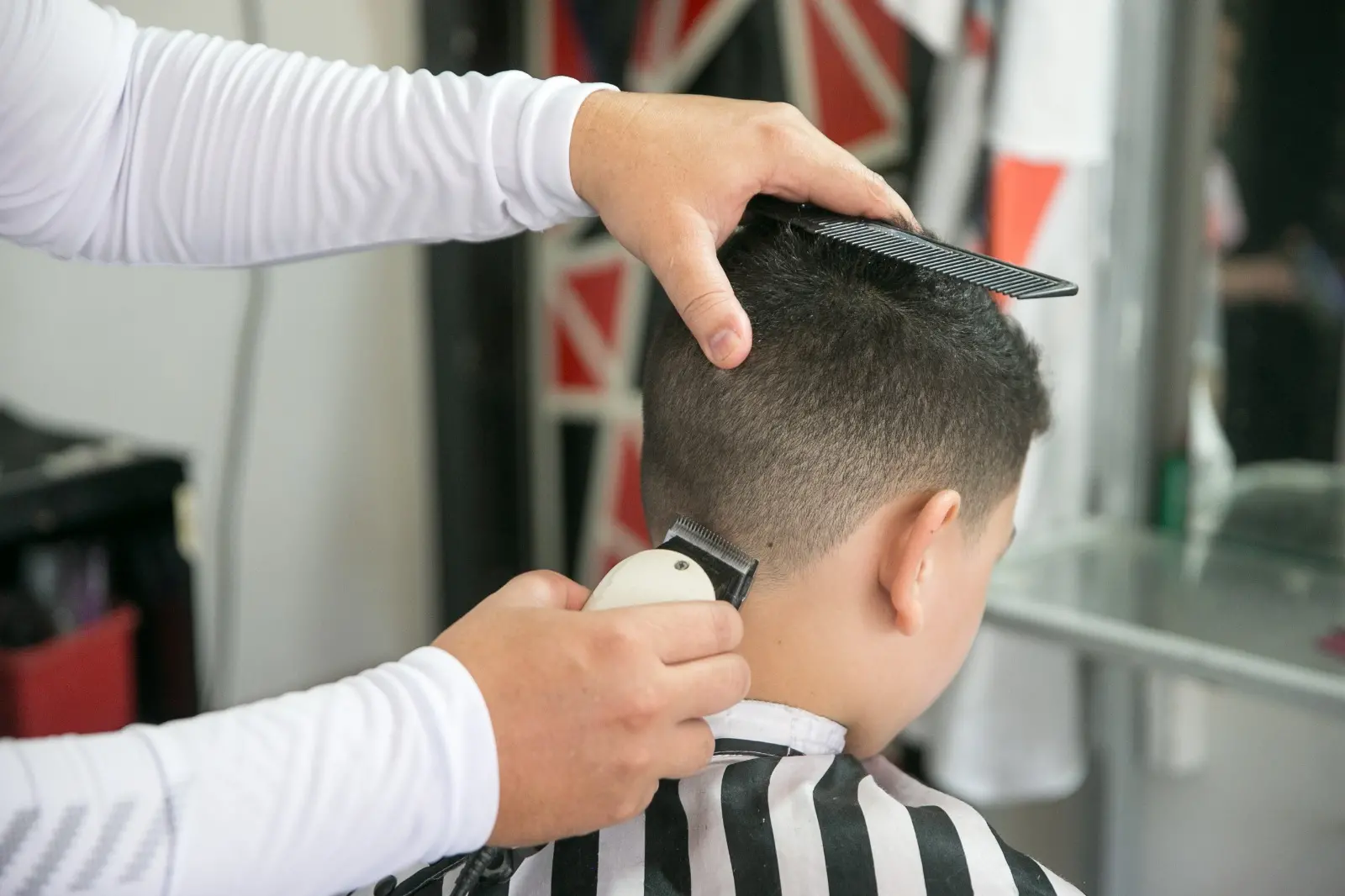 Foto que contém pessoa cortando o cabelo