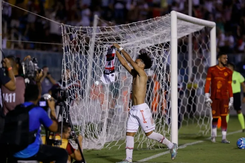 Gabriel Martins comemora acesso erguendo a camisa do Tubarão da Barra.