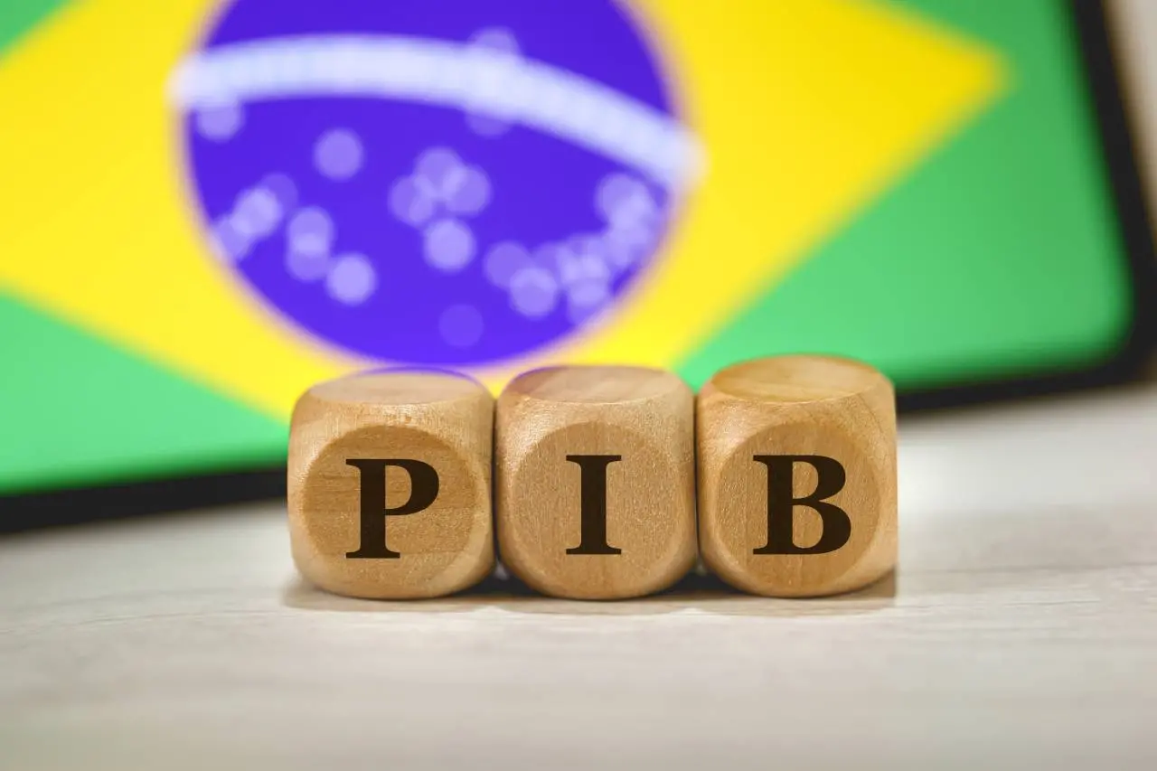 Letras formando PIB com bandeira do Brasil ao fundo