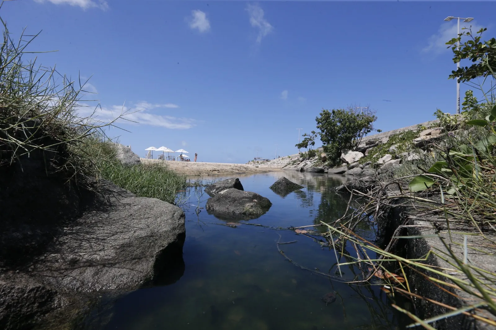 Trecho na praia, usado para comércio e lazer, tem odor fétido com o acúmulo de esgoto