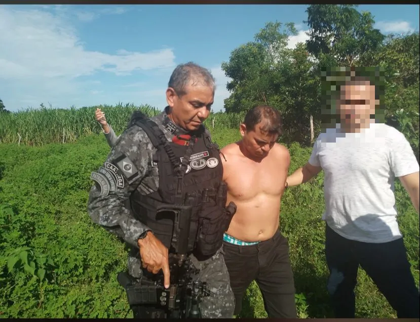 O tenente-coronel PM Antônio Cavalcante conduz o preso (sem camisa) com outro policial (identidade preservada)