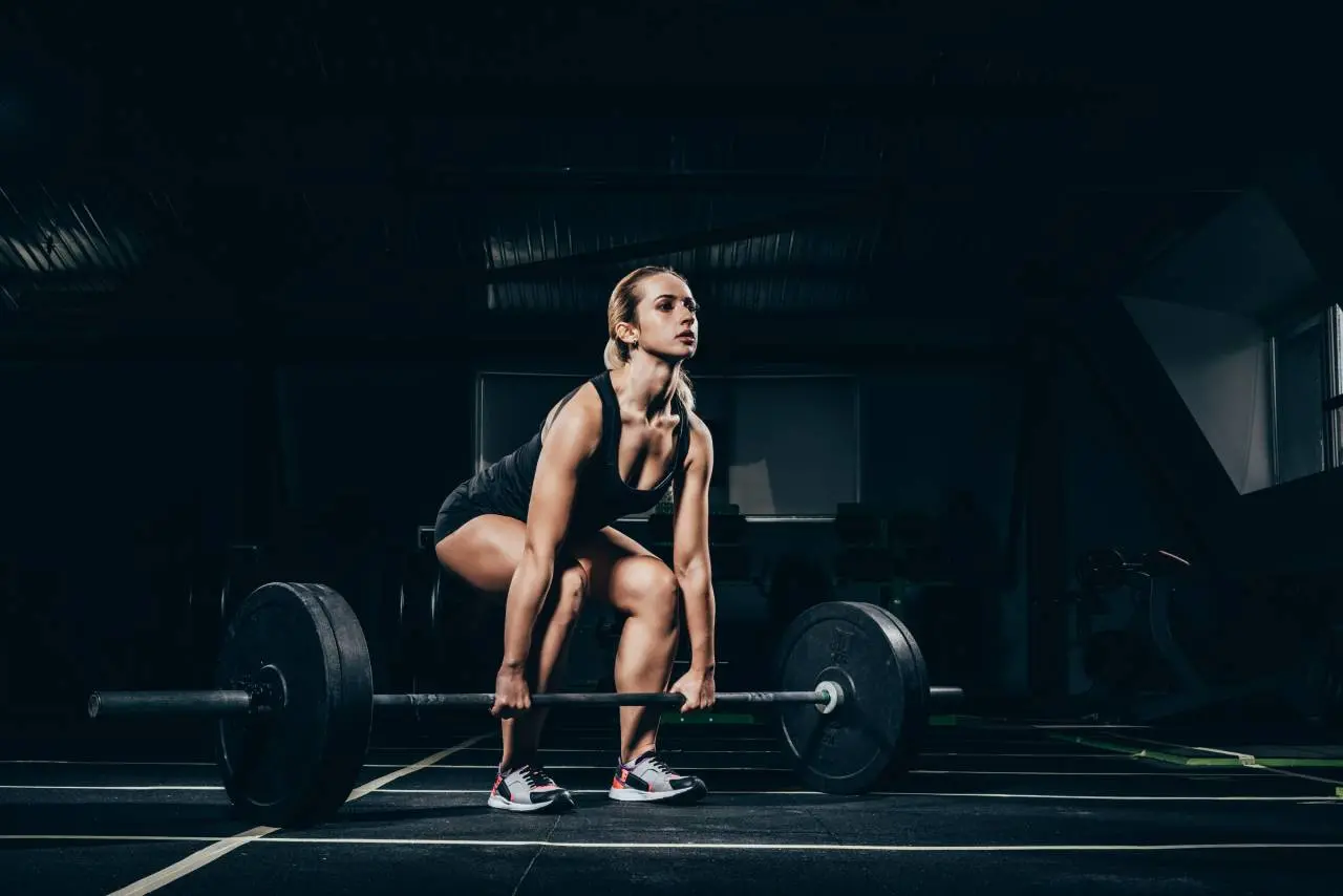 Mulher levantando peso em academia