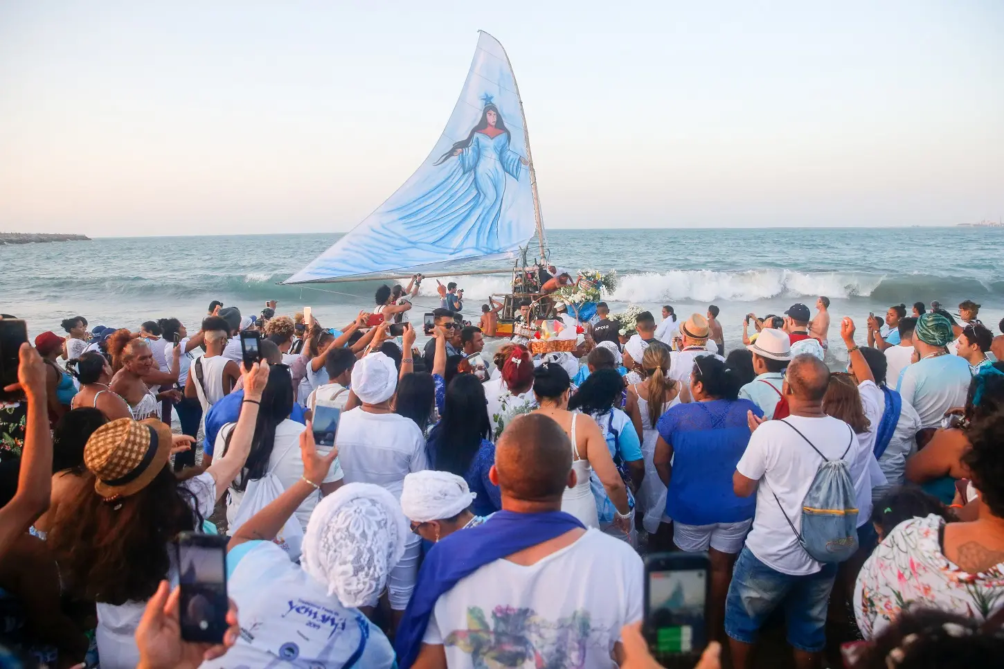 População observa jangada com pintura de Iemanjá na vela