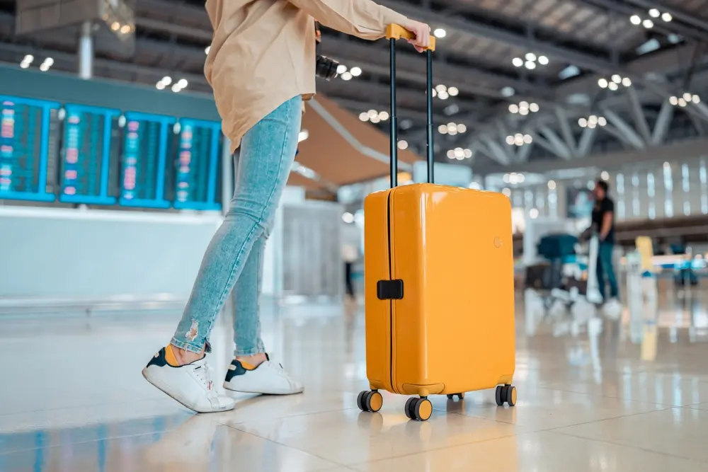 Mulher segurando mala de mão em aeroporto