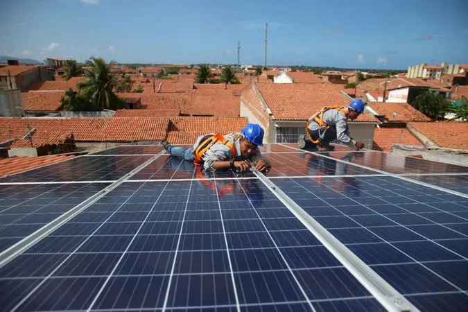 Técnicos instalando painéis de energia solar em residências