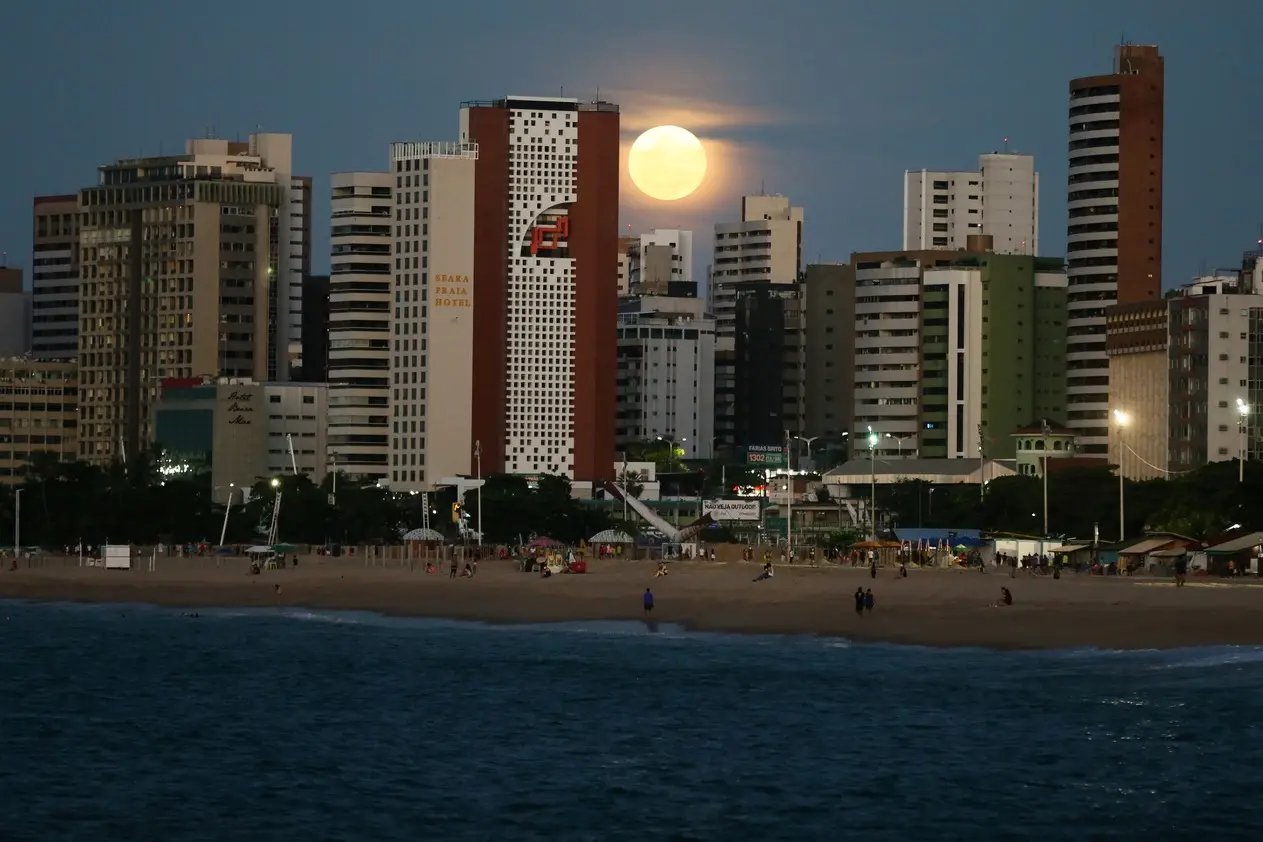 Imagem de superlua e prédios à noite