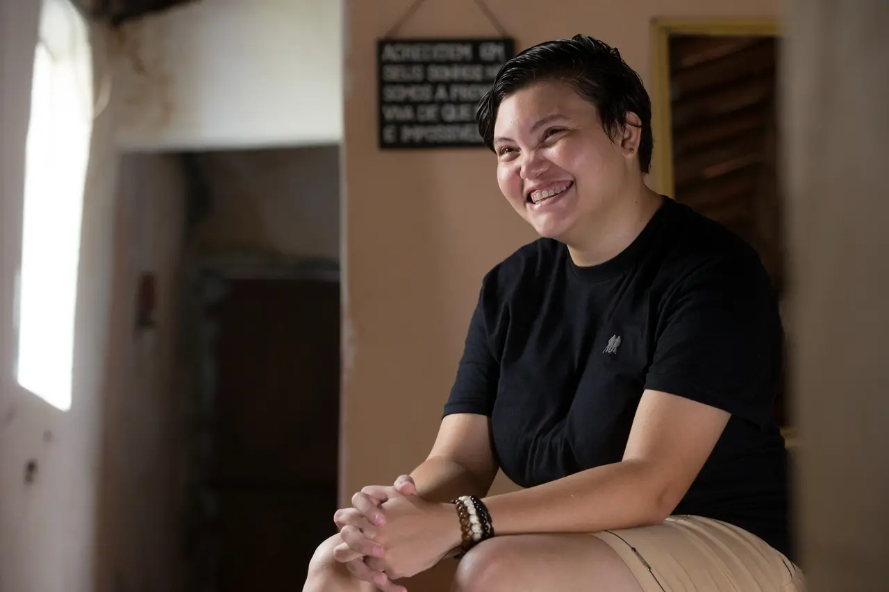 Brena, sentada, sorrindo