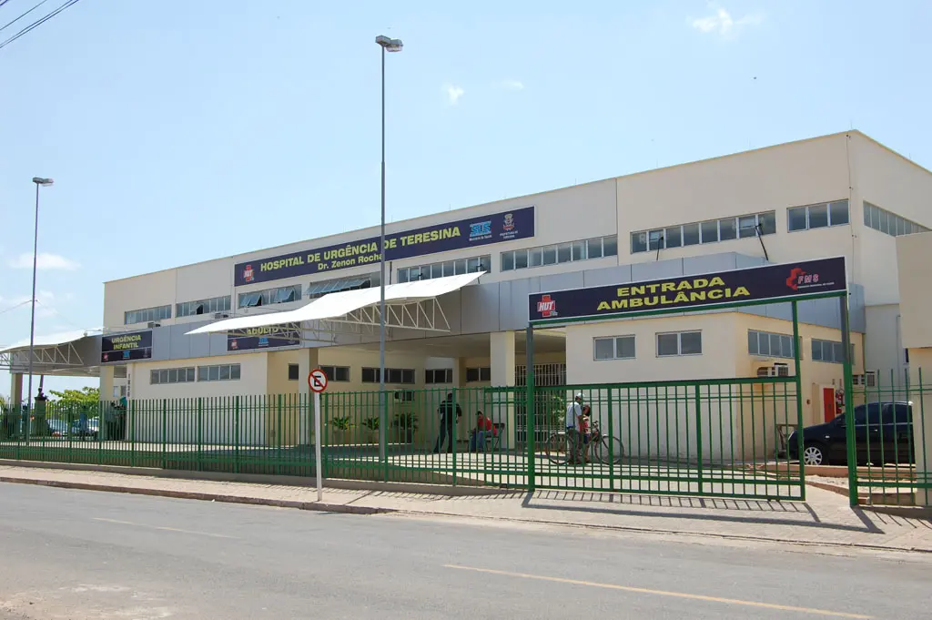 Fachada do Hospital de Urgência de Teresina, com entrada da ambulância visível e sinalizações de orientação em destaque.