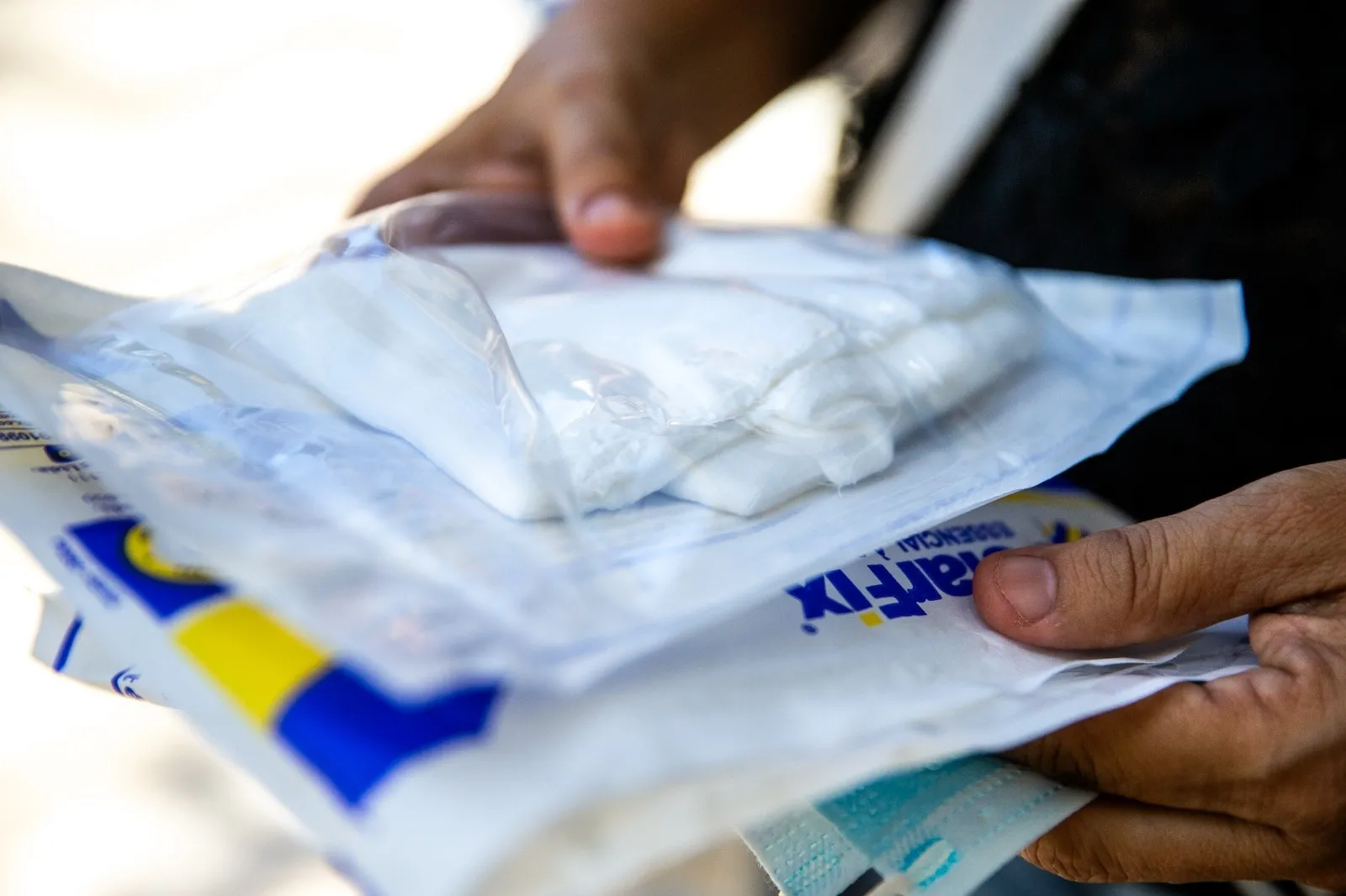 Acompanhante de paciente do IJF com pacotes de gaze na mão, durante falta de medicamentos e insumos no hospital