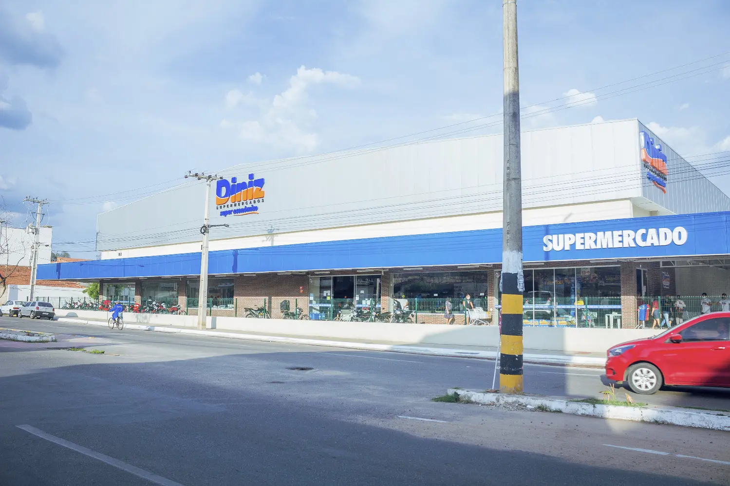 Foto que contém a fachada do Diniz Supermercados em uma avenida de Juazeiro do Norte