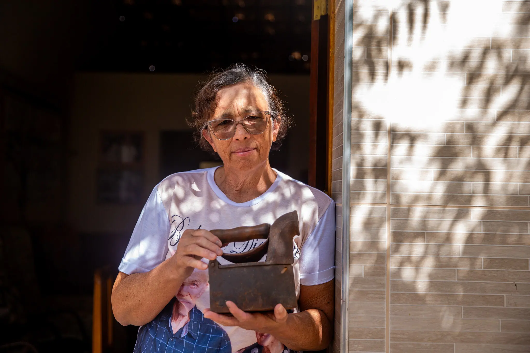 Professora Jeanne segura um ferro de passar roupa antigo