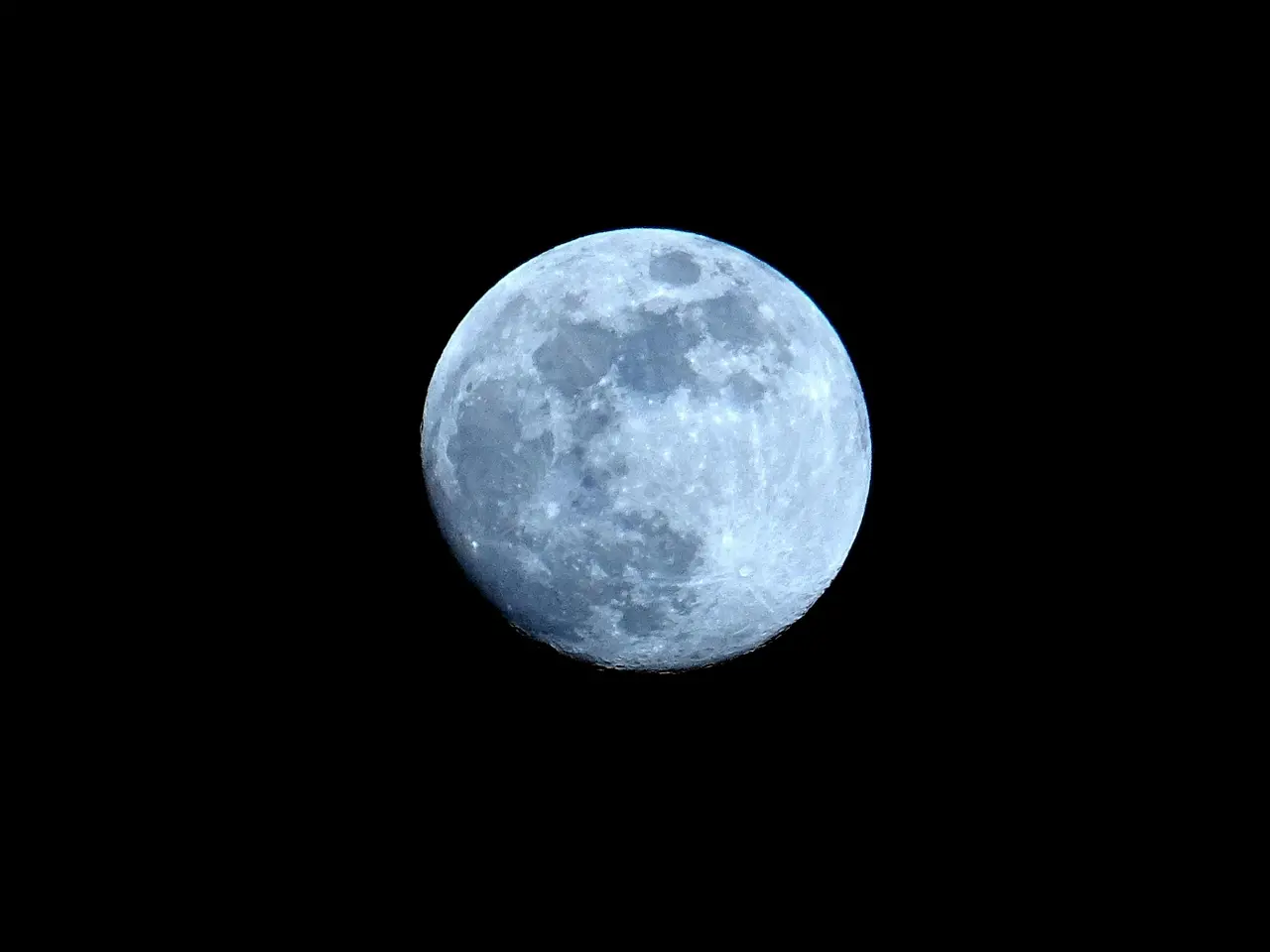 Imagem da lua em leve tom de azul em um fundo preto