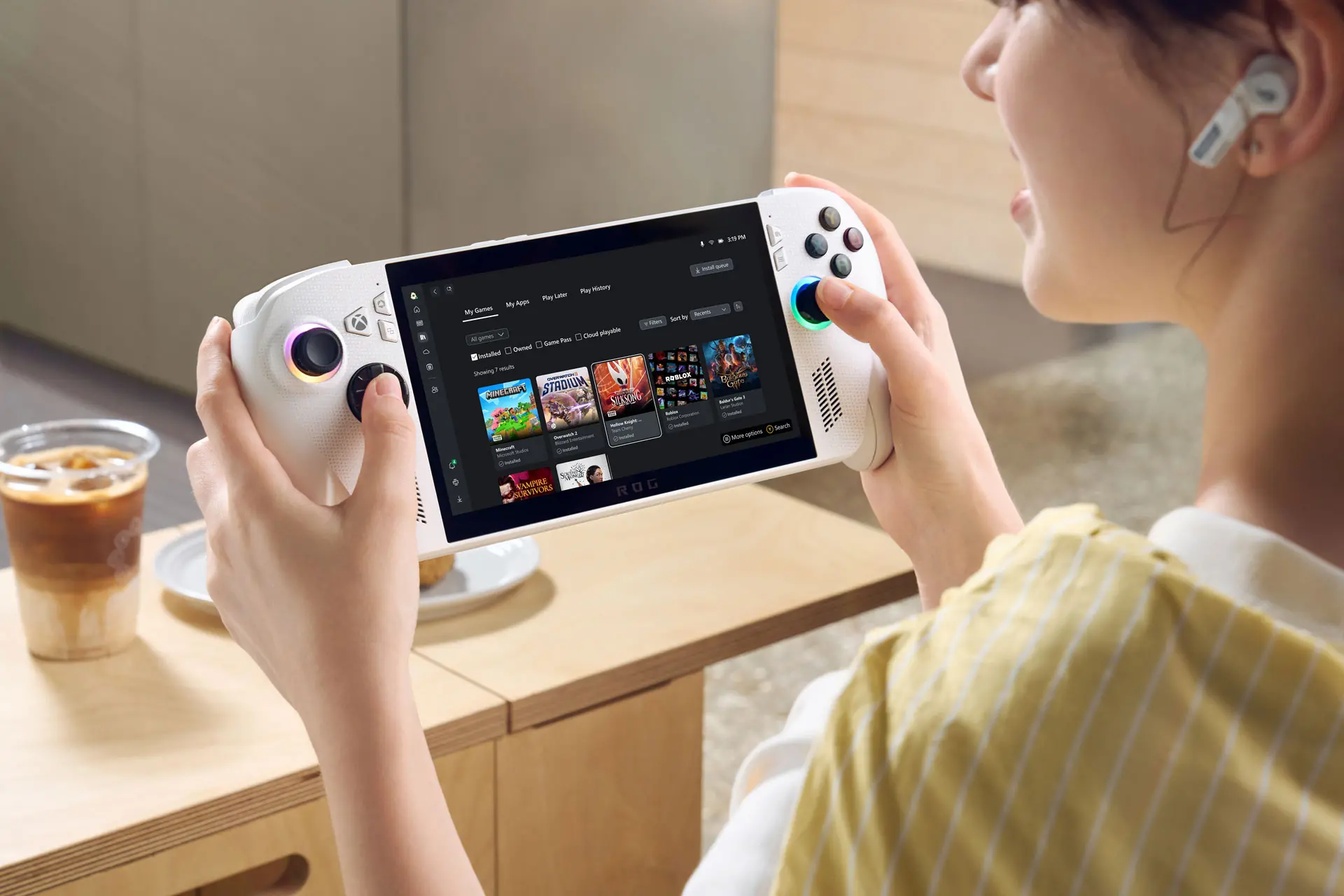 Jovem jogando videogame portátil com controles coloridos, realizando uma partida de jogos em uma sala de estar moderna.