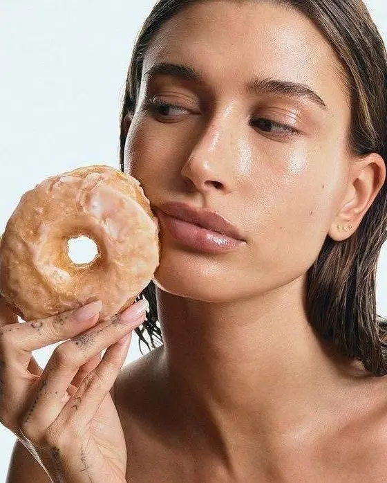 Quantas publis e campanhas vimos nos últimos meses onde a comida virou um super acessório? Na imagem, campanha da Rhode com Hailey Bieber