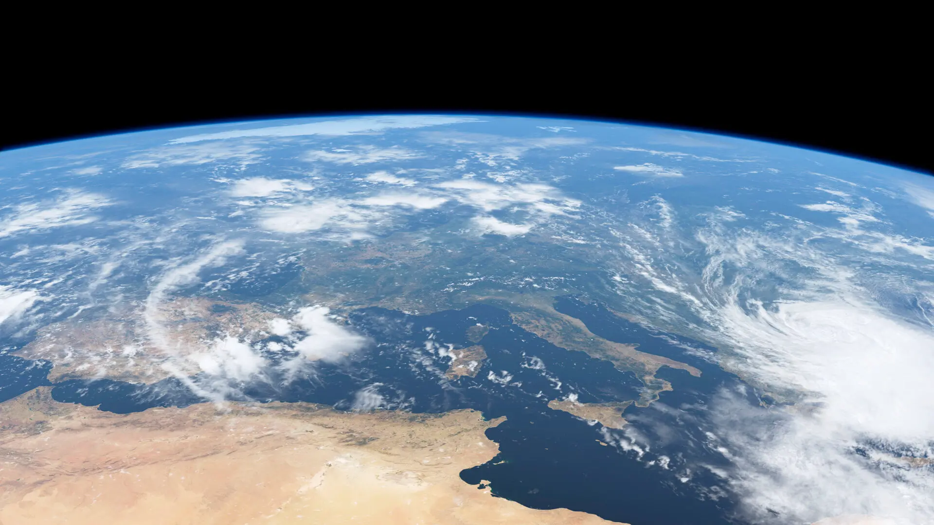 Imagem mostra vista da Terra direto do espaço. Apenas o topo do planeta aparece, em tons azuis e terrosos.