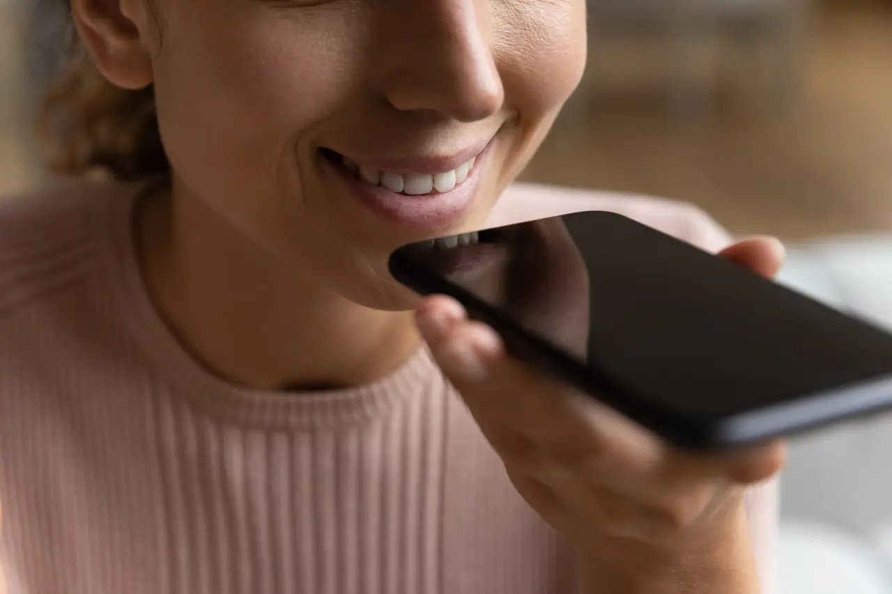Mulher enviando áudio pelo telefone, ilustrando decisão da Justiça que manteve demissão por justa causa de funcionária que usou foto da internet