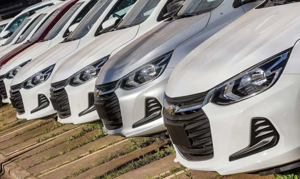 Foto que contém uma série de carros, mostrando sobretudo o para-choque
