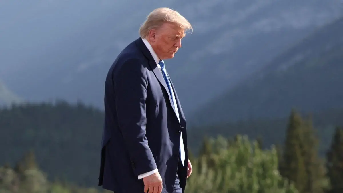 Presidente dos EUA, Donald Trump, andando com cabeça baixa