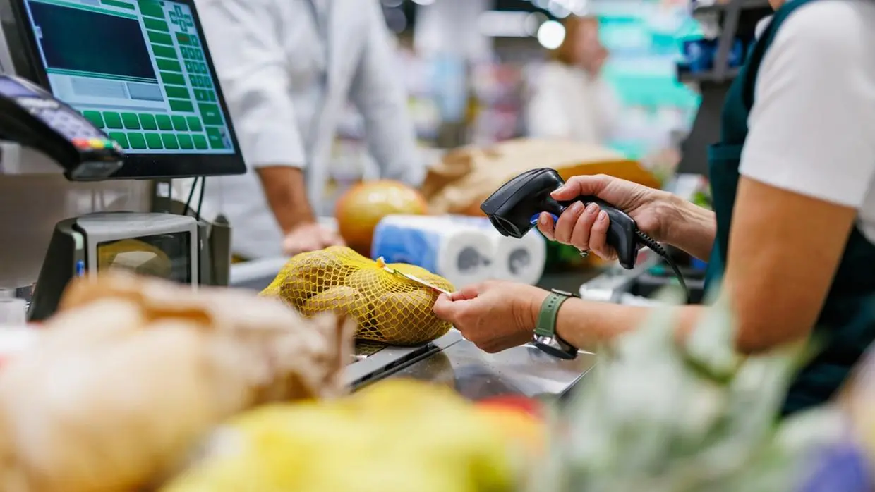 Caixa de supermercado passando itens na esteira