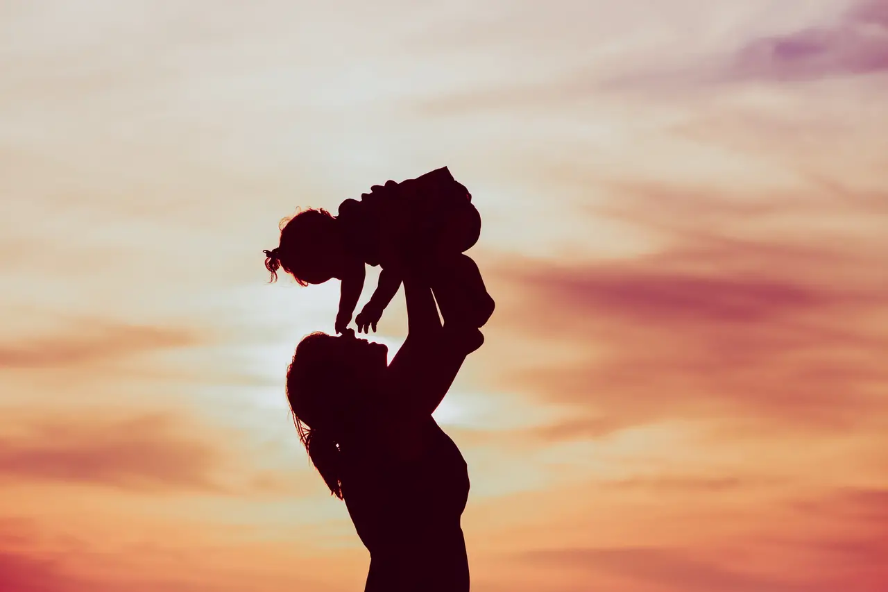 imagem de mãe com bebe sombreada para falar da falta de creche e do peso das mães