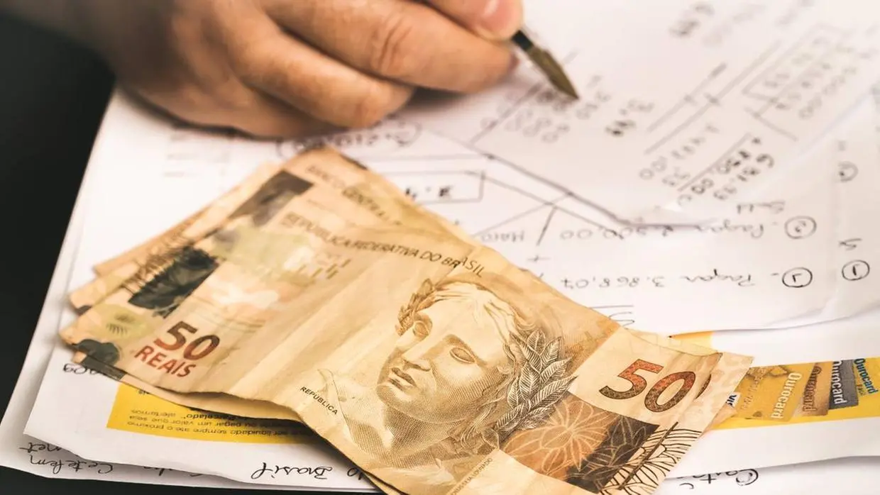 Cédulas sobre a mesa e um carden