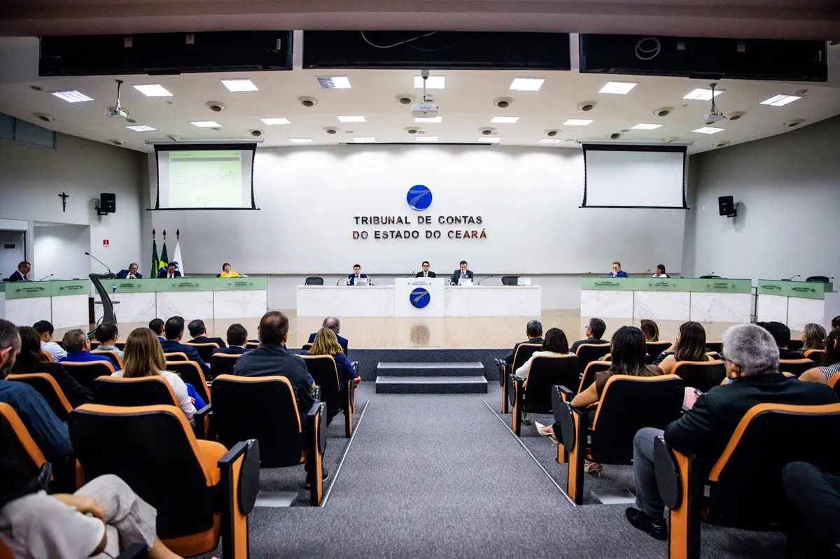 Sessão no plenário do Tribunal de Contas do Estado do Ceará, com conselheiros na mesa diretora e público acompanhando nas cadeiras do auditório.