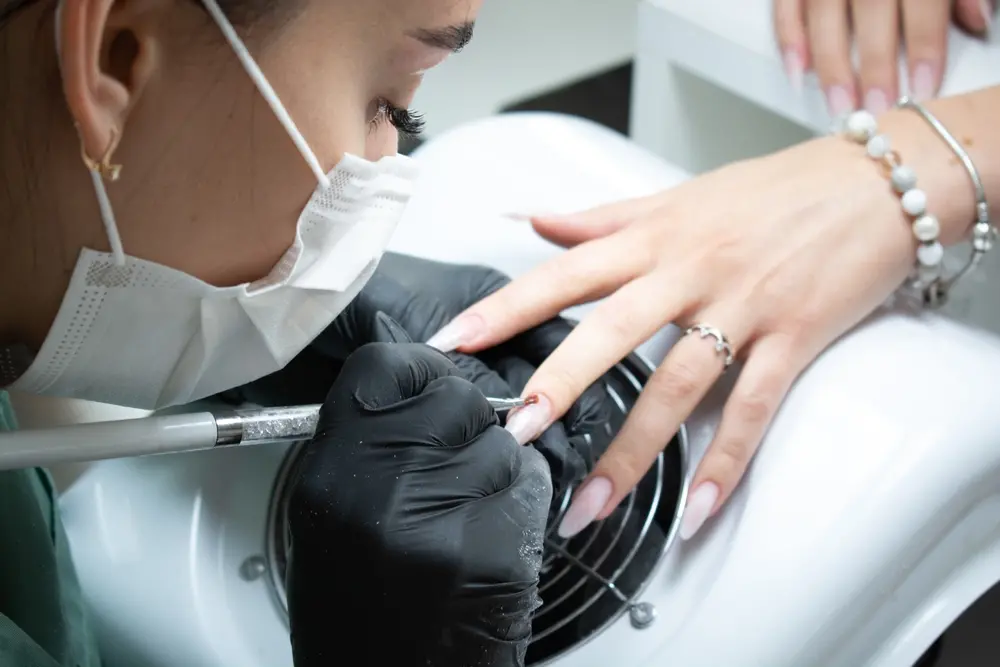 foto de profissional aplicando unha em gel em cliente